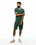 Dark green Mens Garry Jacquard Johnny Collar Polo and matching shorts, featuring an all-over Psycho Bunny skull logo jacquard pattern, classic fit, and white collar with sleeve trim.