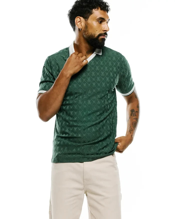 Mens Garry Jacquard Johnny Collar Polo in deep green, featuring an all-over tonal jacquard pattern of the iconic Psycho Bunny skull logo, a crisp white Johnny collar, and white striped sleeve cuffs, offering a refined slim fit.
