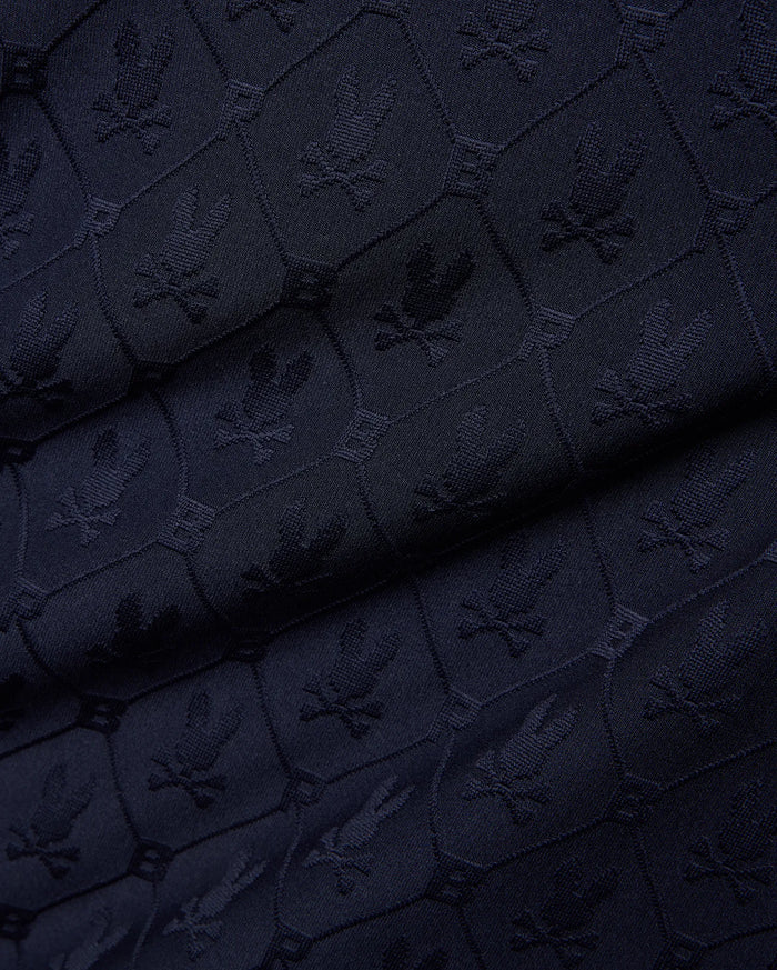 Mens Garry Jacquard Johnny Collar Polo in dark navy, featuring an all-over tone-on-tone jacquard knit pattern of the iconic Psycho Bunny skull logo within hexagonal shapes.