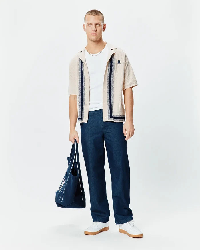 Mens Giles Relaxed Fit Border Knit Shirt in beige, featuring a textured knit fabric, navy blue vertical stripes, a collar, and a small embroidered Psycho Bunny skull logo on the left chest.