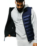 Mens Gordler Reversible Vest, a classic fit navy blue quilted puffer with full zip, reversing to matte black. Embroidered Psycho Bunny skull logo on left chest, smaller blue logo inside.