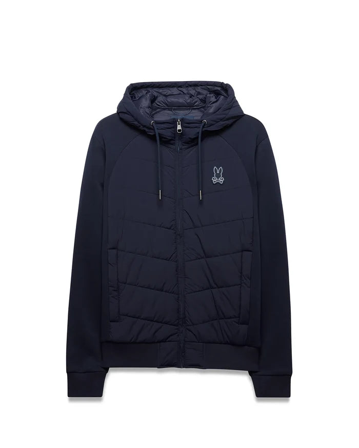 Mens Gordley Mix Media Jacket in navy, full-zip, with a quilted front panel, smooth raglan sleeves, ribbed cuffs and hem, and a small embroidered white Psycho Bunny skull logo on the left chest.