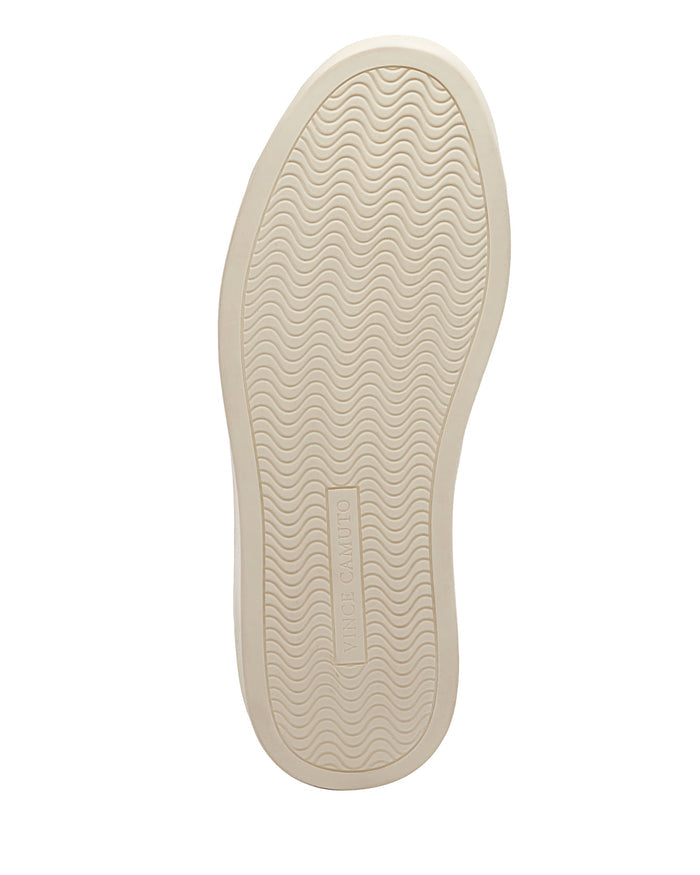 The image depicts the underside of the Vince Camuto Men’s Hallman Casual Sneaker in beige, featuring a wavy textured sole and a rectangular section with the Vince Camuto logo, highlighting the brand’s commitment to stylish design and comfortable wear.