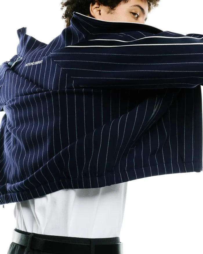 Mens Harland Double Weave Chalk Stripe Track Jacket, a premium navy streetwear piece with crisp white pinstripes, bold white sleeve and collar stripes, and the iconic Psycho Bunny text branding on the upper back.
