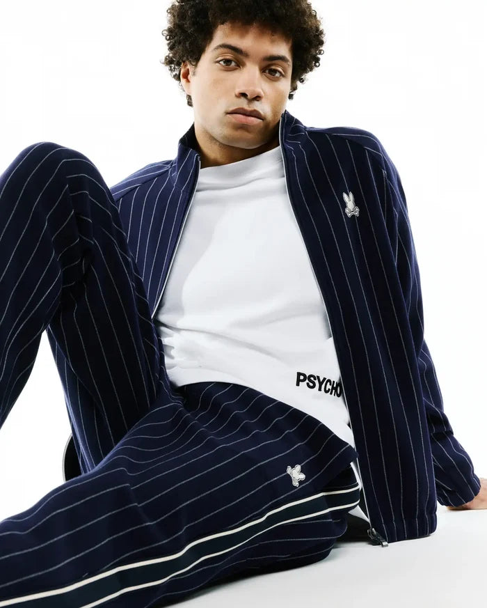 Navy blue chalk stripe track jacket with embroidered bunny skull logo on chest, matching Mens Harland Double Weave Chalk Stripe Track Pant with side stripes and logo, over a white PSYCHO t-shirt.