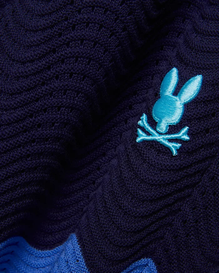 Mens Holden Knit Short in navy with a textured open-knit wavy pattern, featuring a small embroidered turquoise Psycho Bunny skull logo and a bright blue knit stripe.