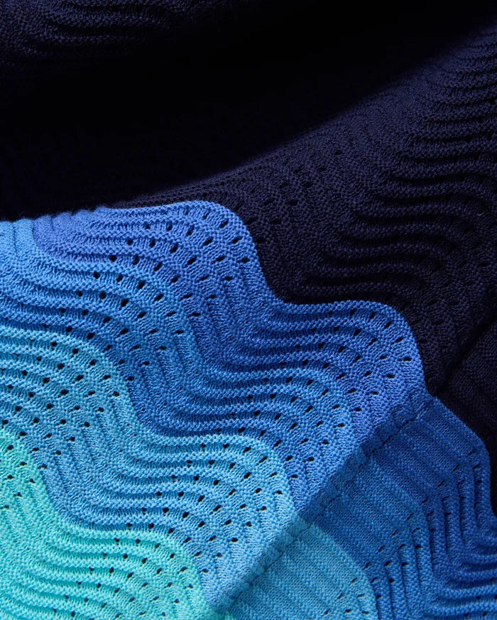 Mens Holden Oversized Knit Shirt featuring a gradient of deep navy to vibrant aqua and medium blue, with a distinctive wavy, open-knit pattern creating a perforated texture.
