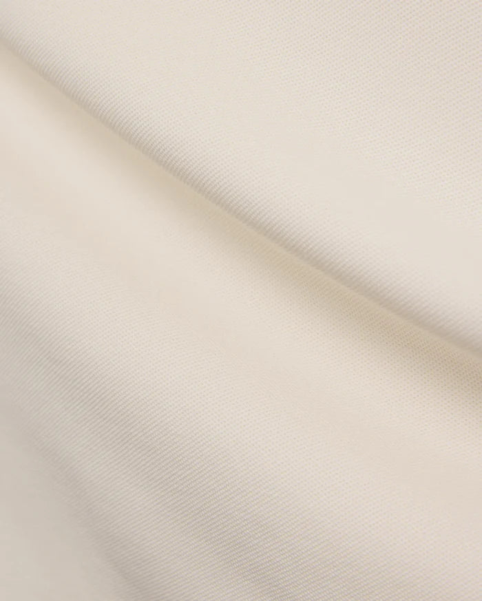 Cream Mens Holden Pique Polo, showcasing its textured pique knit fabric and the iconic small embroidered Psycho Bunny skull logo on the chest.