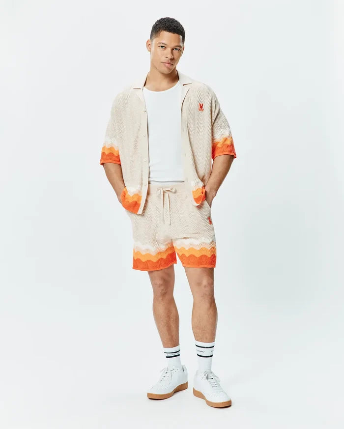 Mens Holden Relaxed Fit Knit Shirt and matching shorts in beige knit with orange and white wavy stripes, featuring a small embroidered orange Psycho Bunny skull logo on the left chest and left thigh.