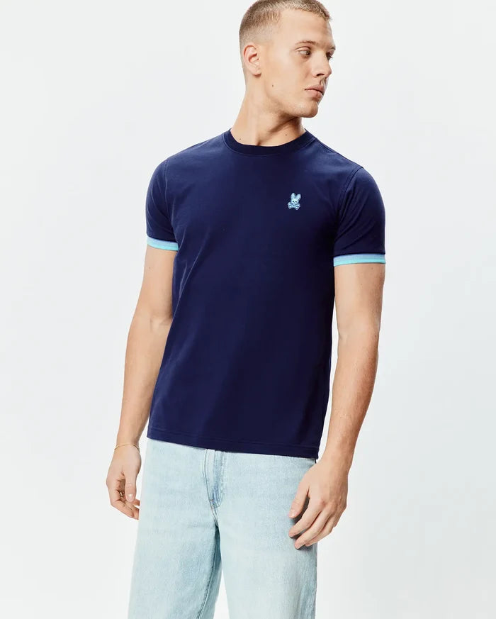 Mens Holden Tee, navy blue jersey t-shirt with a classic fit, featuring light blue ribbed cuffs and a small, embroidered light blue Psycho Bunny skull logo on the left chest.
