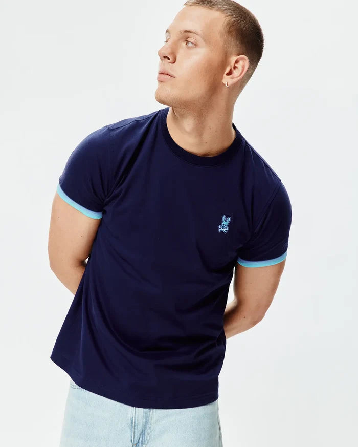 Mens Holden Tee, a classic fit navy blue jersey t-shirt with light blue contrast sleeve cuffs and an embroidered light blue Psycho Bunny skull logo on the left chest.