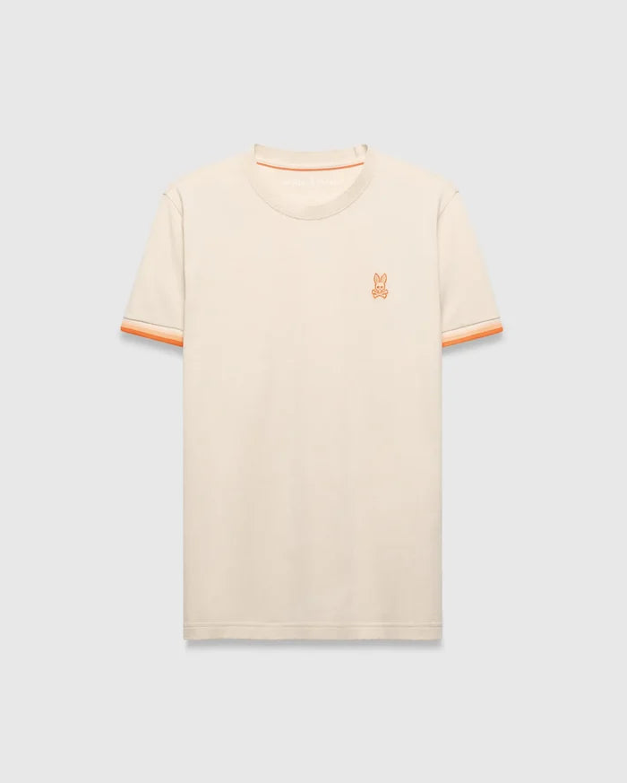 Cream Mens Holden Tee, a classic fit jersey knit t-shirt featuring a small embroidered orange Psycho Bunny skull logo on the left chest and orange striped ribbed sleeve cuffs.