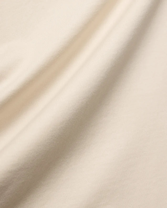 Mens Holden Tee, a premium quality t-shirt in a soft, light beige cotton jersey knit, featuring a smooth texture and elegant drape, characteristic of refined streetwear.