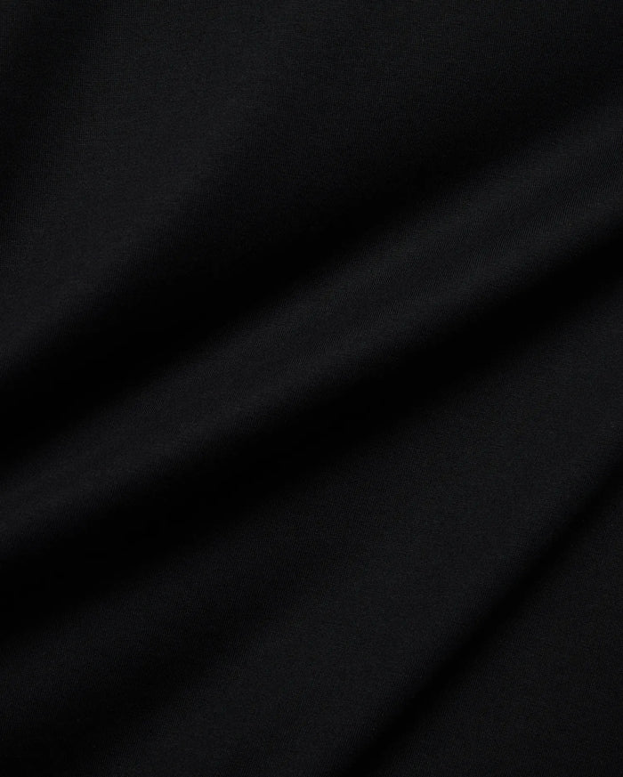 Psycho Bunny Mens Holden Tee in rich black, crafted from soft jersey knit fabric with subtle folds, featuring the iconic small embroidered bunny skull logo on the chest.