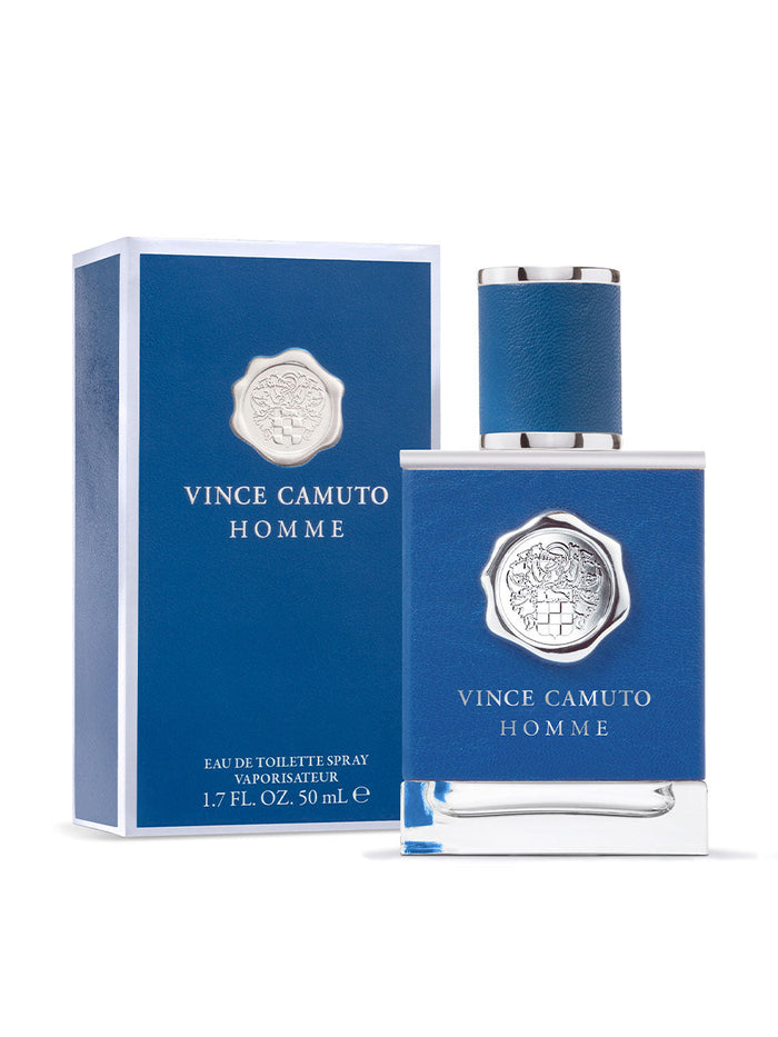 A blue bottle of Vince Camuto Men’s Homme 1.7 oz Eau de Toilette Spray is displayed beside its coordinating blue box, both adorned with silver emblems and text. This fragrance blends notes of pressed citron and Mediterranean blue cypress to evoke a refreshing coastal escape. The bottle contains 1.7 fl. oz. (50 mL).