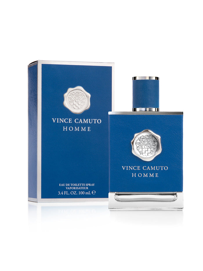 A blue bottle of Vince Camuto Men’s Homme 3.4 oz Eau de Toilette Spray is presented alongside a matching blue box. This sophisticated fragrance is infused with notes of blue cypress and pressed citron. Both the upright bottle and the box are adorned with silver emblem and text, with the box displaying the product details.