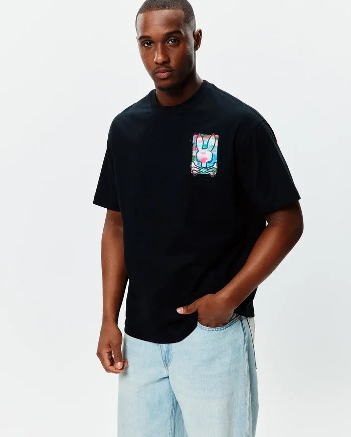 Mens Isaac Relaxed Fit Tee, black jersey with a small chest graphic of the Psycho Bunny skull logo in vibrant pink, blue, green watercolor splatter.