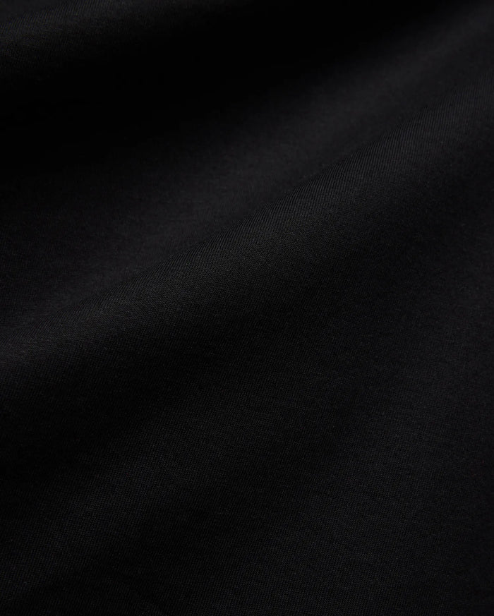 Mens Isaac Relaxed Fit Tee, a premium Psycho Bunny black jersey knit fabric, showcasing its soft, smooth texture with subtle, elegant folds, ideal for refined streetwear.