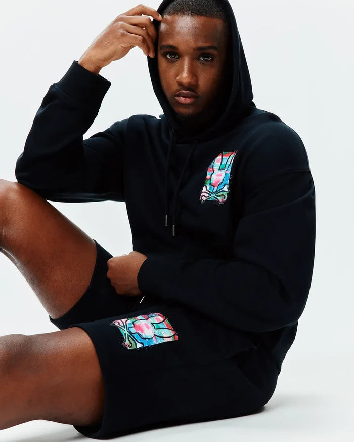 Black relaxed fit hoodie and Mens Isaac Print Short, both in soft jersey, featuring a vibrant multi-color Psycho Bunny skull logo on the left chest and left thigh.