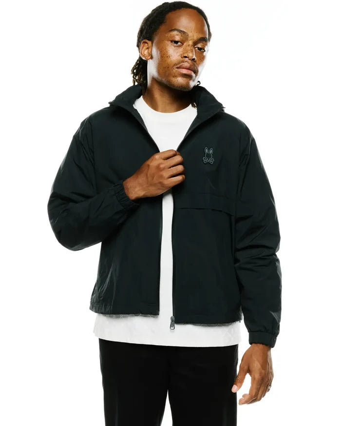 Mens Javier Nylon Windbreaker Jacket, dark forest green, relaxed fit, smooth nylon, full-zip, stand-up collar, elastic cuffs, with an embroidered Psycho Bunny skull logo on the left chest.