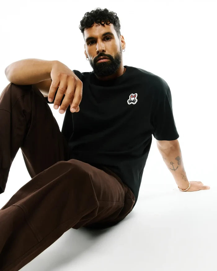 Mens Jaydon Pima Cotton Oversized-Fit Tee, a black smooth Pima cotton jersey t-shirt with a small, embroidered Psycho Bunny skull logo on the left chest, featuring red eyes and white outline.