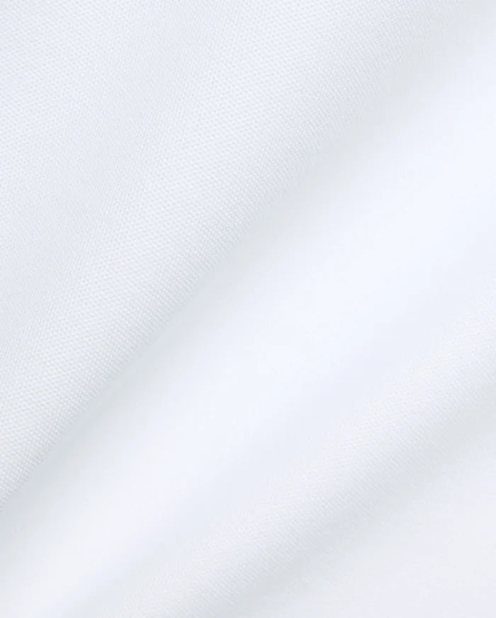 Psycho Bunny Mens Jaydon Pique Polo in crisp white, featuring the iconic brand's premium textured pique fabric with subtle folds, embodying refined streetwear.