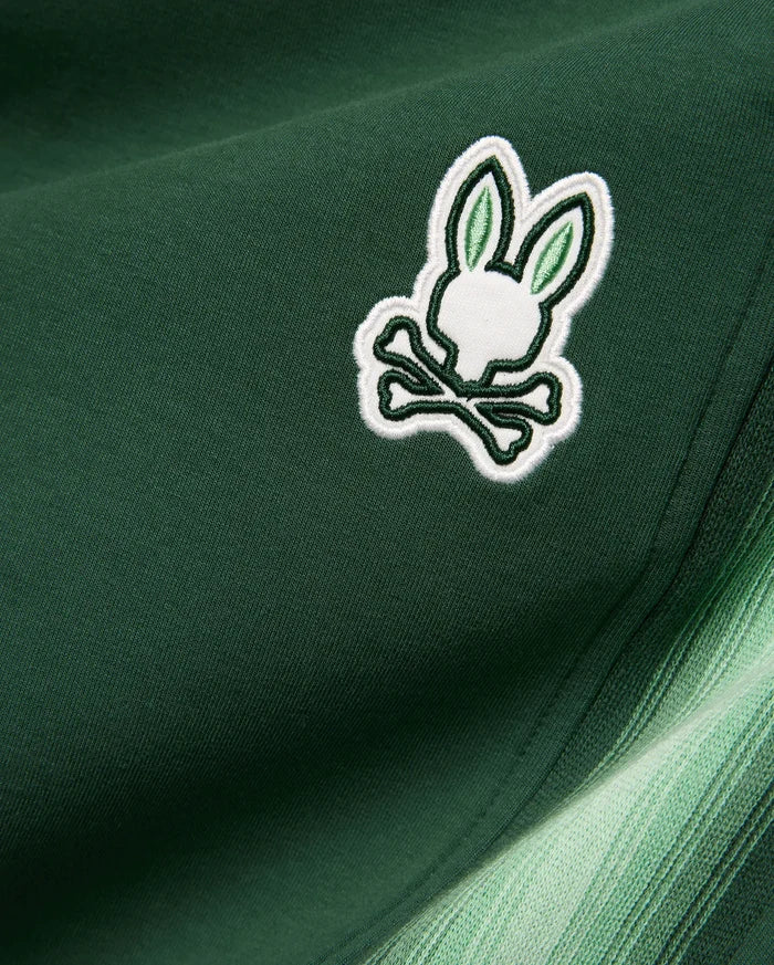 Mens Jaydon Track Pant in dark green smooth knit, featuring a small embroidered white and light green Psycho Bunny skull logo and a side stripe with a green gradient.