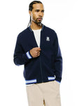 Mens Jaydon Track Jacket in navy blue, featuring a classic fit, smooth knit fabric, full zip, and a small embroidered white Psycho Bunny skull logo on the left chest. Ribbed collar, cuffs, and hem have white and blue stripes.