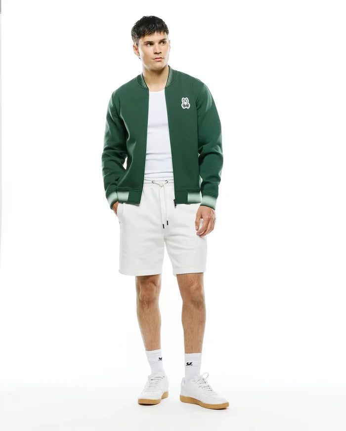 Mens Jaydon Track Jacket in dark green, featuring a classic fit, smooth knit fabric, full zip closure, and white/light green striped ribbed collar, cuffs, and hem, with an embroidered white Psycho Bunny skull logo on the left chest.