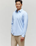 A man wearing the Psycho Bunny MENS JIM JERSEY STRIPED KNIT SHIRT (MT0300041) and beige pants stands against a plain light background, looking forward with a relaxed expression.