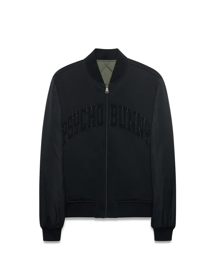Mens Joaquin Mix Media Reversible Bomber in black with large tonal PSYCHO BUNNY chest text, full zip with skull logo pull, ribbed trim, and olive green quilted reverse side.