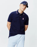 Navy blue Mens John Pique Polo, classic fit, with white two-button placket, ribbed collar and cuffs featuring red and white tipping, and an embroidered Psycho Bunny skull logo on the left chest.
