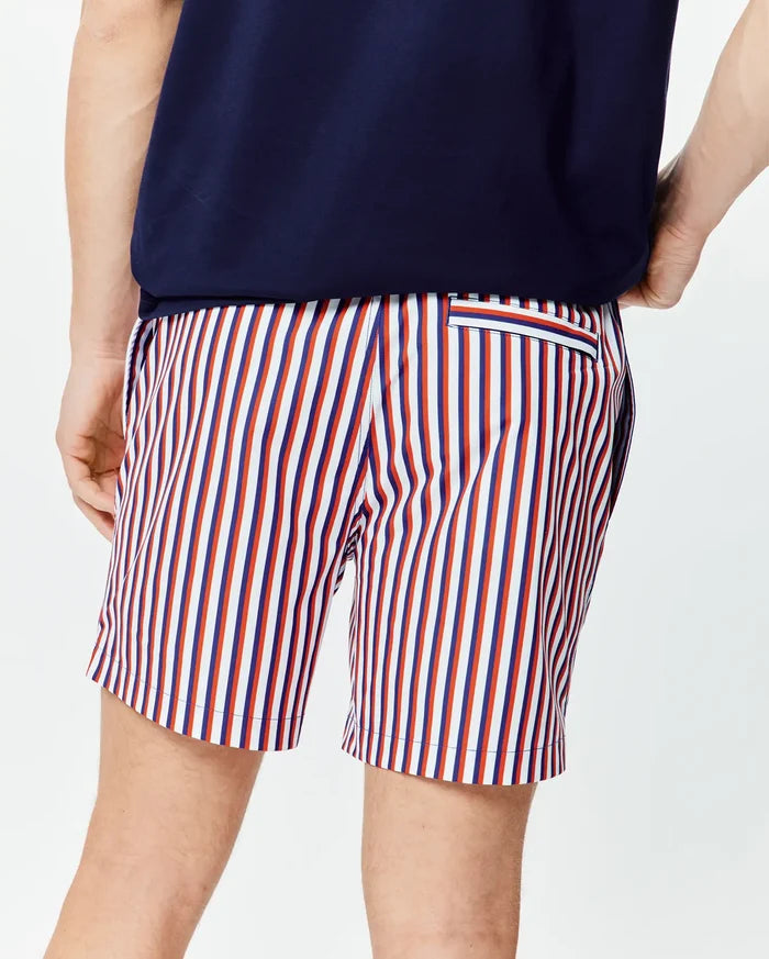 Mens John All Over Print Swim Trunk, a classic fit with vibrant vertical stripes in white, red, and navy blue, featuring a small striped back pocket on smooth fabric.