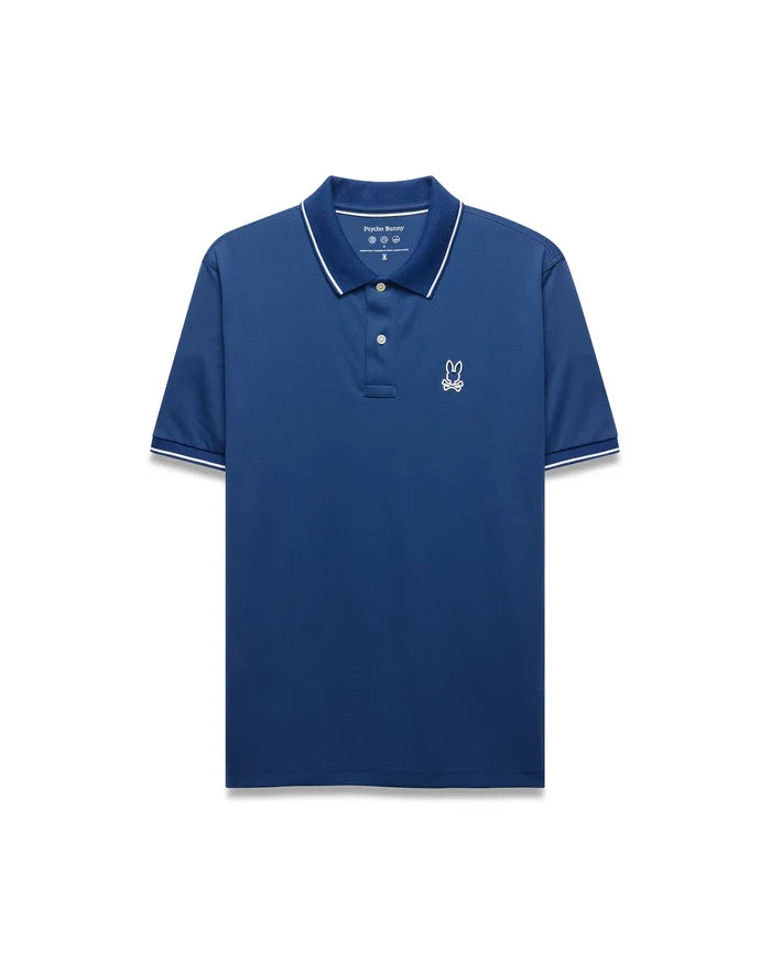 Mens Joji Performance Polo, a deep blue classic fit polo with a smooth performance fabric, features a white embroidered Psycho Bunny skull logo on the left chest and white tipping on the collar and cuffs.