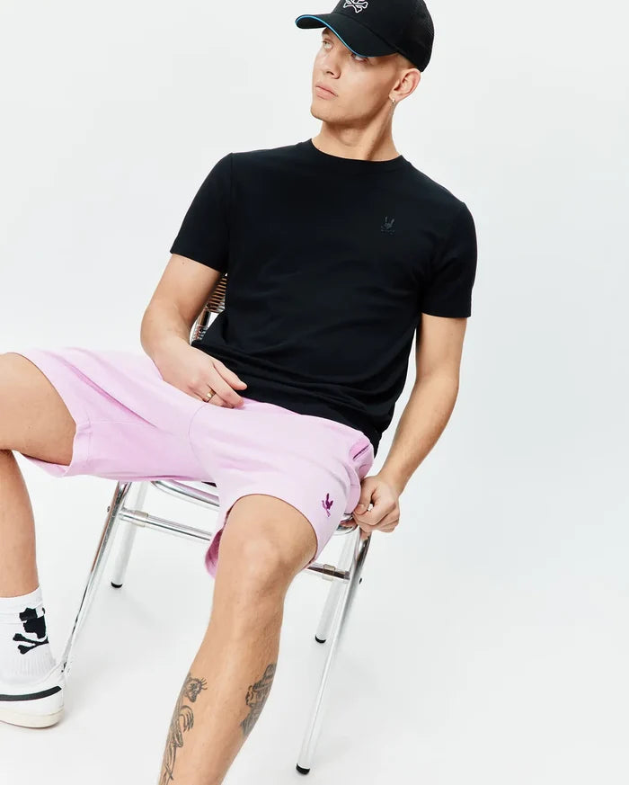 Black classic fit jersey t-shirt with tonal Psycho Bunny skull on chest; light pink Mens Keith Short 8 relaxed pique shorts with purple Psycho Bunny skull on thigh.