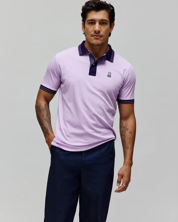 Mens Kenyon Lightweight Pique Polo in light purple, featuring a navy collar with white tipping, a two-button placket, ribbed cuffs with matching stripes, and a small embroidered Psycho Bunny skull logo on the left chest.