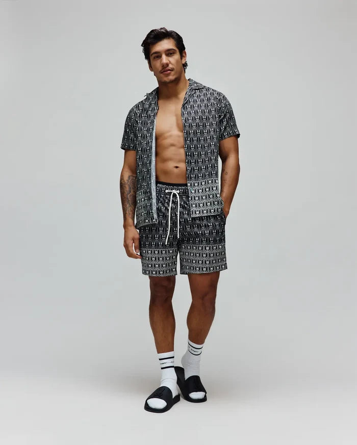 Mens Keon Tencel Shirt, a relaxed fit black Tencel short-sleeve shirt, and matching shorts, both featuring a white all-over Psycho Bunny skull logo pattern and white drawstrings.