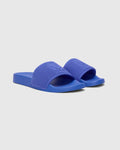 Mens Knit Slides in vibrant royal blue, showcasing a textured knitted strap with a prominent embossed Psycho Bunny skull logo, set on a smooth matching sole.