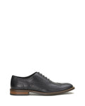 The Men’s Lazzarp Wingtip Brogue by Vince Camuto is shown in side profile on a white background, featuring black luxe leather with decorative perforations, a lace-up closure, and a brown sole. Crafted for all-day comfort with Flex365 technology.