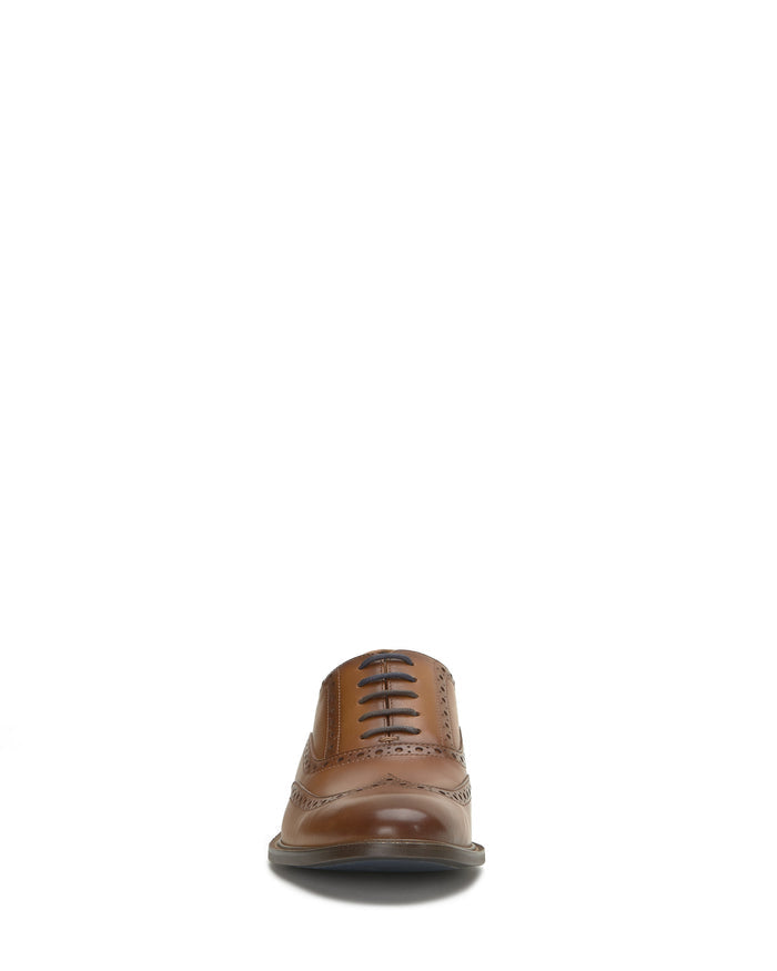 Front view of the Vince Camuto Men’s Lazzarp Wingtip Brogue, featuring luxe leather, black laces, decorative perforations, and a low heel—perfect for elevating any office outfit; displayed against a plain white background.