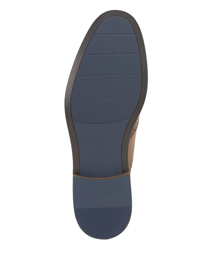 A close-up view of the sole of the Vince Camuto Men’s Lazzarp Wingtip Brogue showcases a blue, textured rubber bottom with horizontal grooves and a small circular logo near the center—an ideal finishing touch to elevate any office outfit.