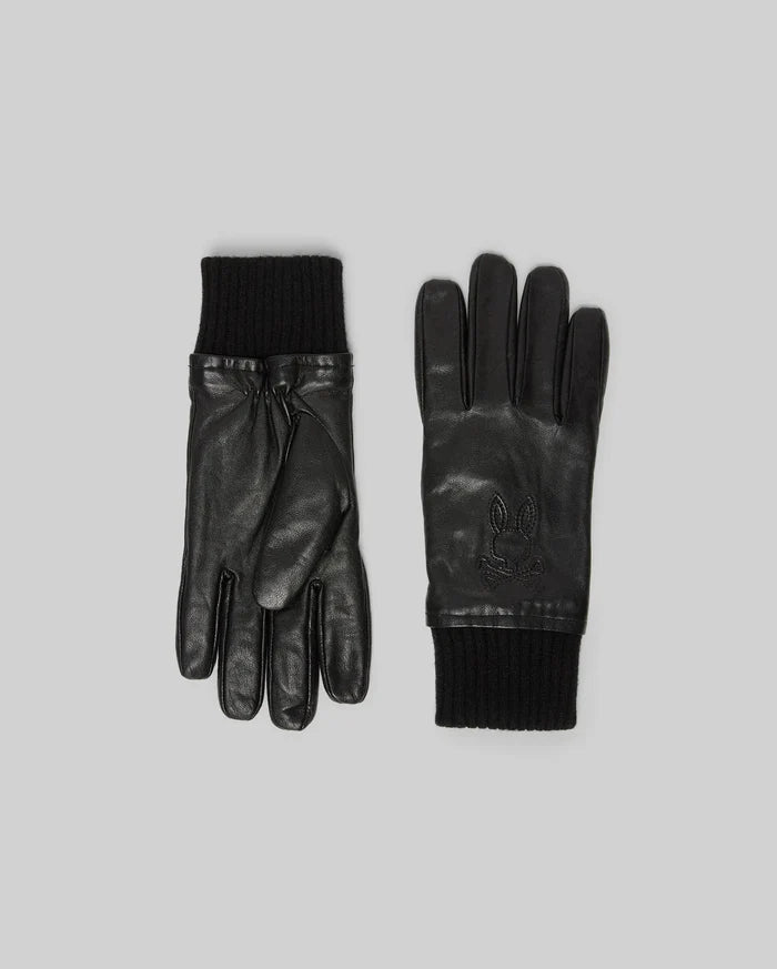 Black Mens Leather Gloves with smooth texture, featuring black ribbed knit cuffs and an embossed Psycho Bunny skull logo on the back of the hand.