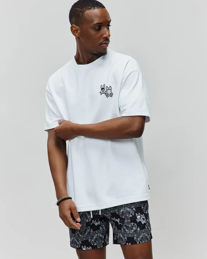 White Mens Luke Back Graphic Tee, a relaxed fit jersey t-shirt featuring a small embroidered black Psycho Bunny skull logo on the left chest and a subtle hem tag.