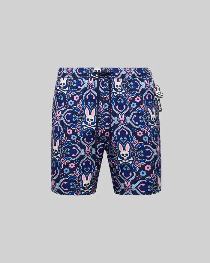 Mens Luke Swim Trunk in navy blue with an allover pink, light blue, and white intricate paisley, floral, and Psycho Bunny skull pattern. Features a drawstring waist and a small rubberized Psycho Bunny tag.