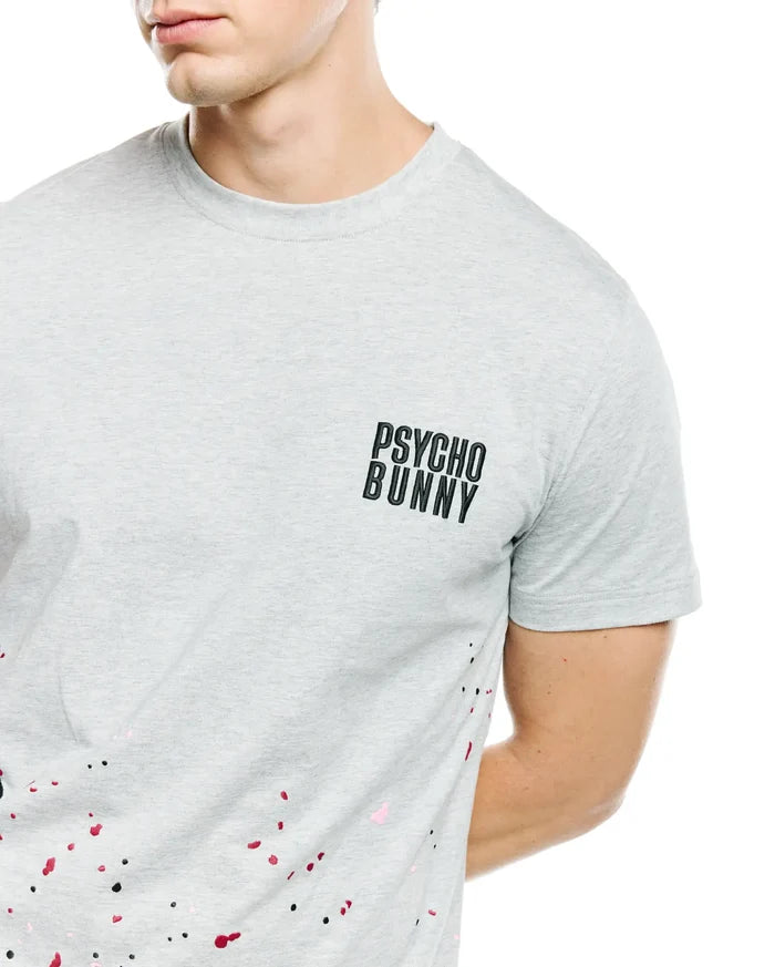 Mens Malcolm Graphic Tee, heather grey classic fit jersey t-shirt with small black Psycho Bunny text logo on left chest and vibrant black, red, and pink paint splatter graphic.