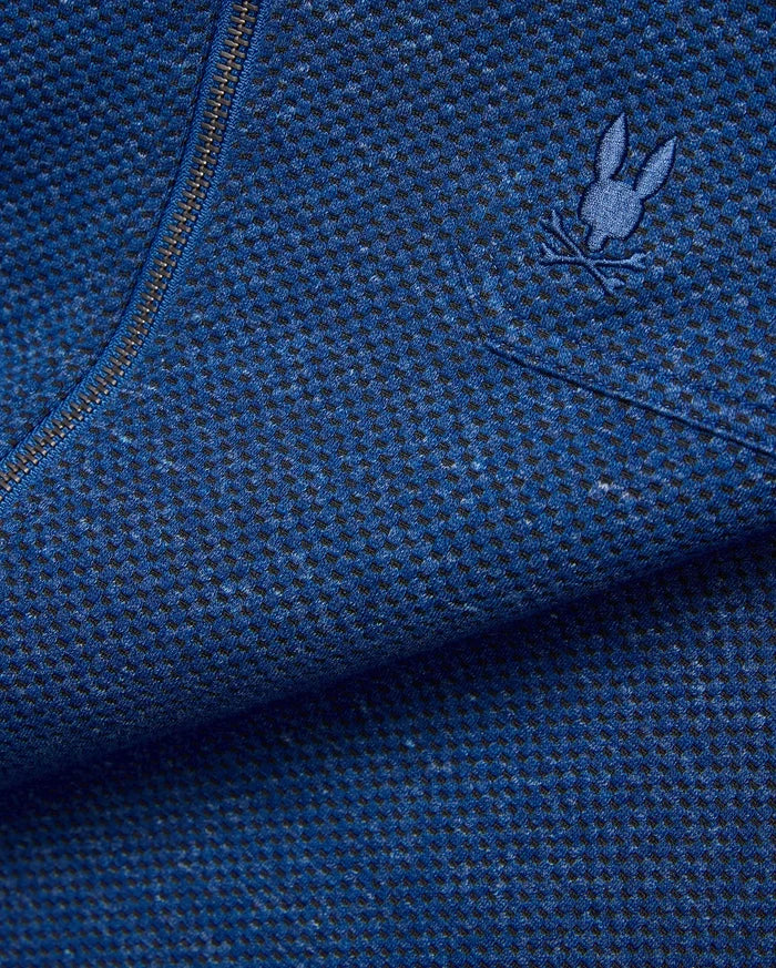 Mens Marc Textured Overshirt in deep blue heathered knit fabric with black flecks, featuring a dark metallic zipper and a small embroidered blue Psycho Bunny skull logo on the chest.