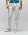 Mens Maverick 10k Step Pant, light beige, slim fit, smooth premium fabric, with a small embroidered green Psycho Bunny skull logo on the right front pocket.