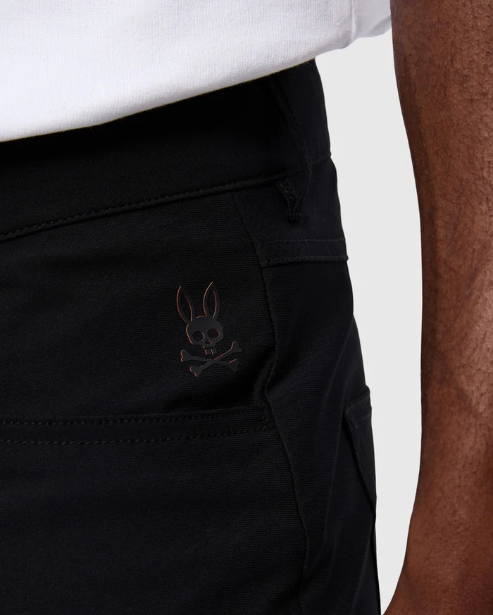 Mens Maverick 10k Step Pant 31 1/2 L in black smooth woven fabric, featuring a small metallic bronze embroidered Psycho Bunny skull logo on the upper left thigh.