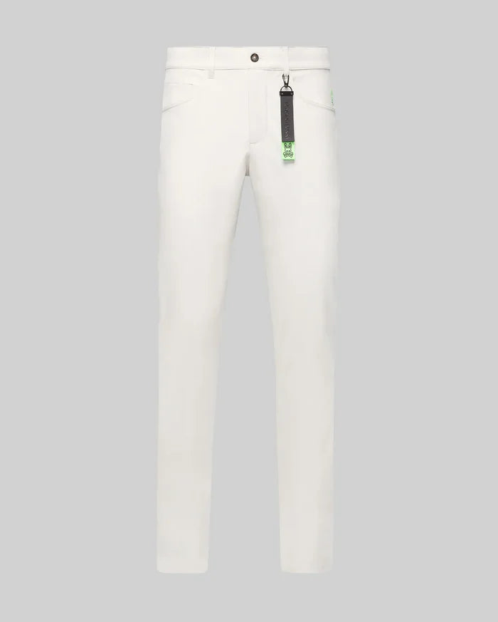 Mens Maverick 10k Step Pant in white, featuring a straight fit, smooth fabric, and a small embroidered neon green Psycho Bunny skull logo on the right hip. A black and neon green branded keychain hangs from a belt loop.