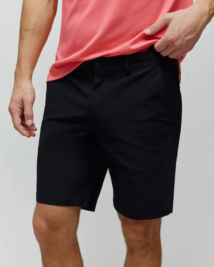 Mens Maverick 10k Step Short, classic fit black shorts made from smooth fabric, featuring a flat front, button closure, belt loops, and a small, tonal embroidered Psycho Bunny skull logo on the right front pocket.